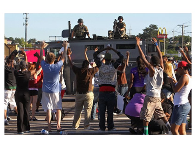 Protesters confront police who are on top of their armored vehicle, Ferguson, August 13. Photo: AP Protesters confront police who are on top of their armored vehicle, Ferguson, August 13. Photo: AP