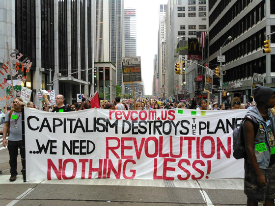 Revcom Banner at the Climate March: 9/21/14 reads Capitalism is destroys the planet We need Revolution Nothing Less