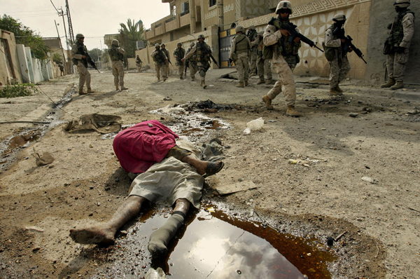 Infantes de la marina pasan a lado de personas muertas durante el asalto de Estados Unidos contra Faluya, Irak, 2004