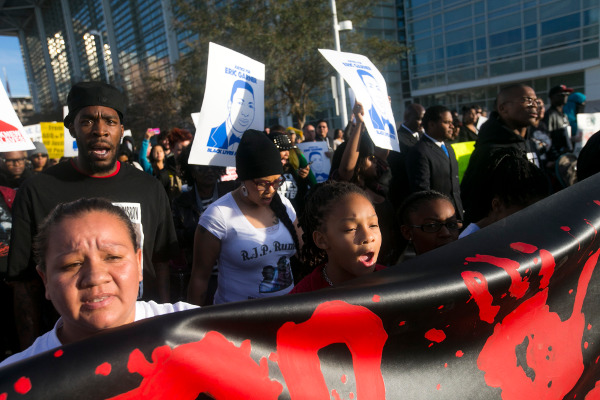 Protesters march in front of the police headquarters against the police murder of Rumain Brisbon--at center is Brisbon's 9-year-old daughter, Aiyana Rains. December 20, 2014.