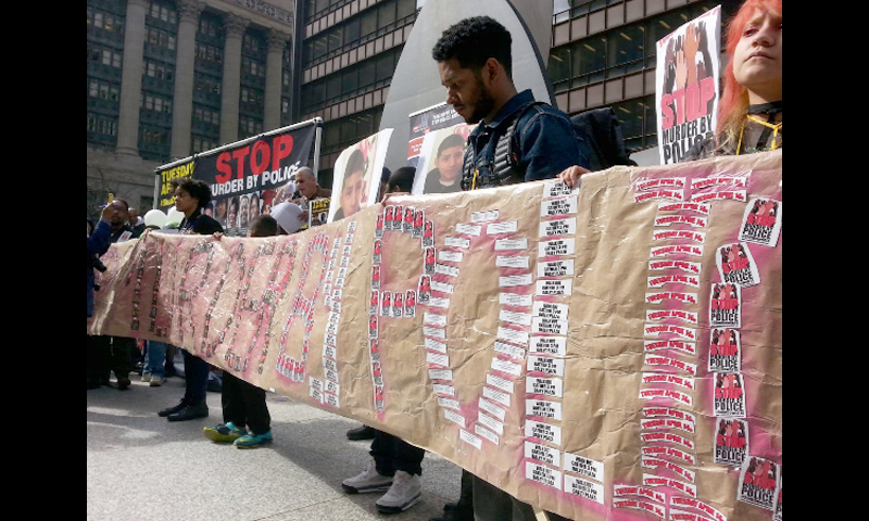 Chicago: Columbia College students with banner made from April 14 shutdown stickers. Photo: special to revcom.us