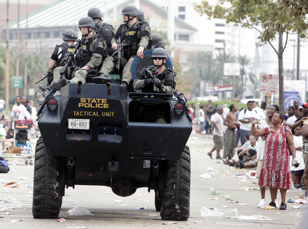 SWAT team drives past flood victims waiting at the Convention Center in New Orleans, Thursday, Sept. 1, 2005.