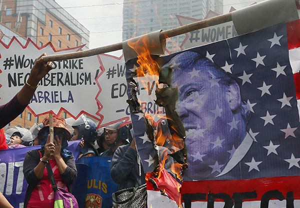 In Manila, Philippines, protesters burned a U.S. flag with Trump's image on it.