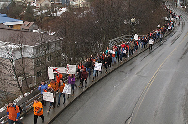 Alumnos corean y portan pancartas en una marcha a Juneau, Alaska