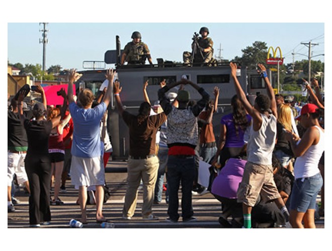 Manifestantes contra policías en portatropas blindado, Ferguson, 13 de agoso. Foto: AP 