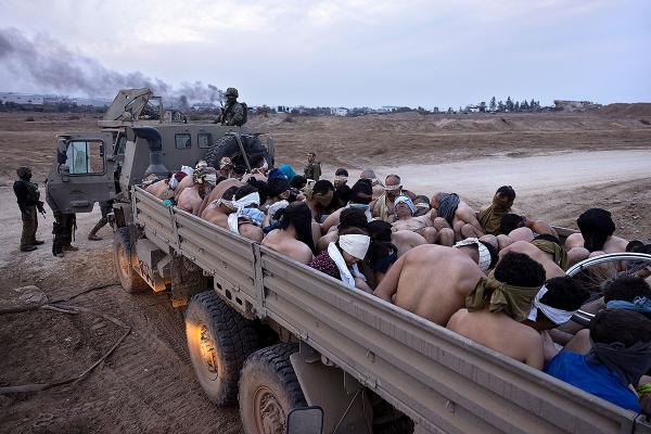 Israeli truck in Gaza packed with Palestinian detainees, bound and blindfolded, December 8, 2023.
