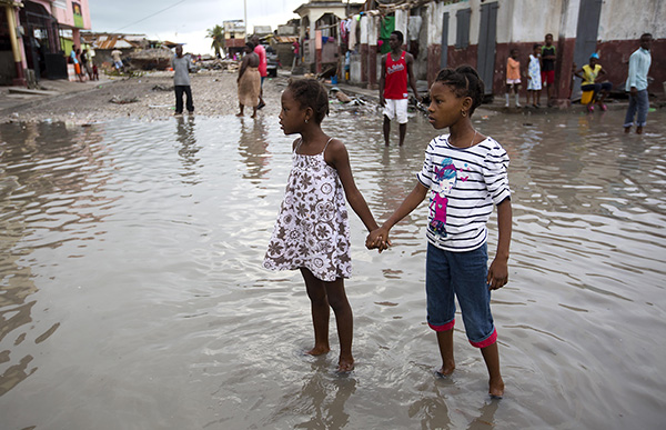Two young girls in Les Cayes, Haiti, wade through a flooded street after the passing of Hurricane Matthew, October 6.