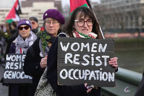 IWD London women for palestine, sign says "Women Resist Occupation."
