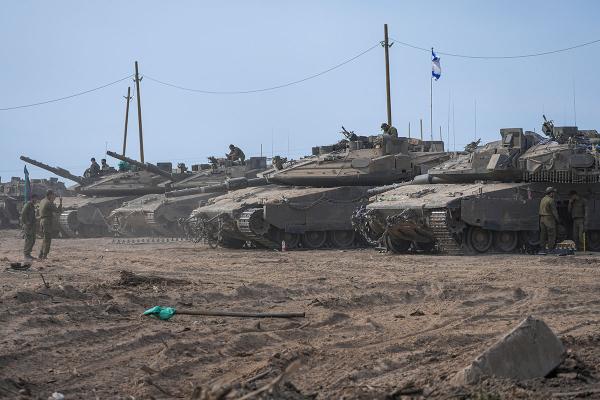 Israeli soldiers work on their tanks near the border with the Gaza Strip, in southern Israel, April 8, 2024.